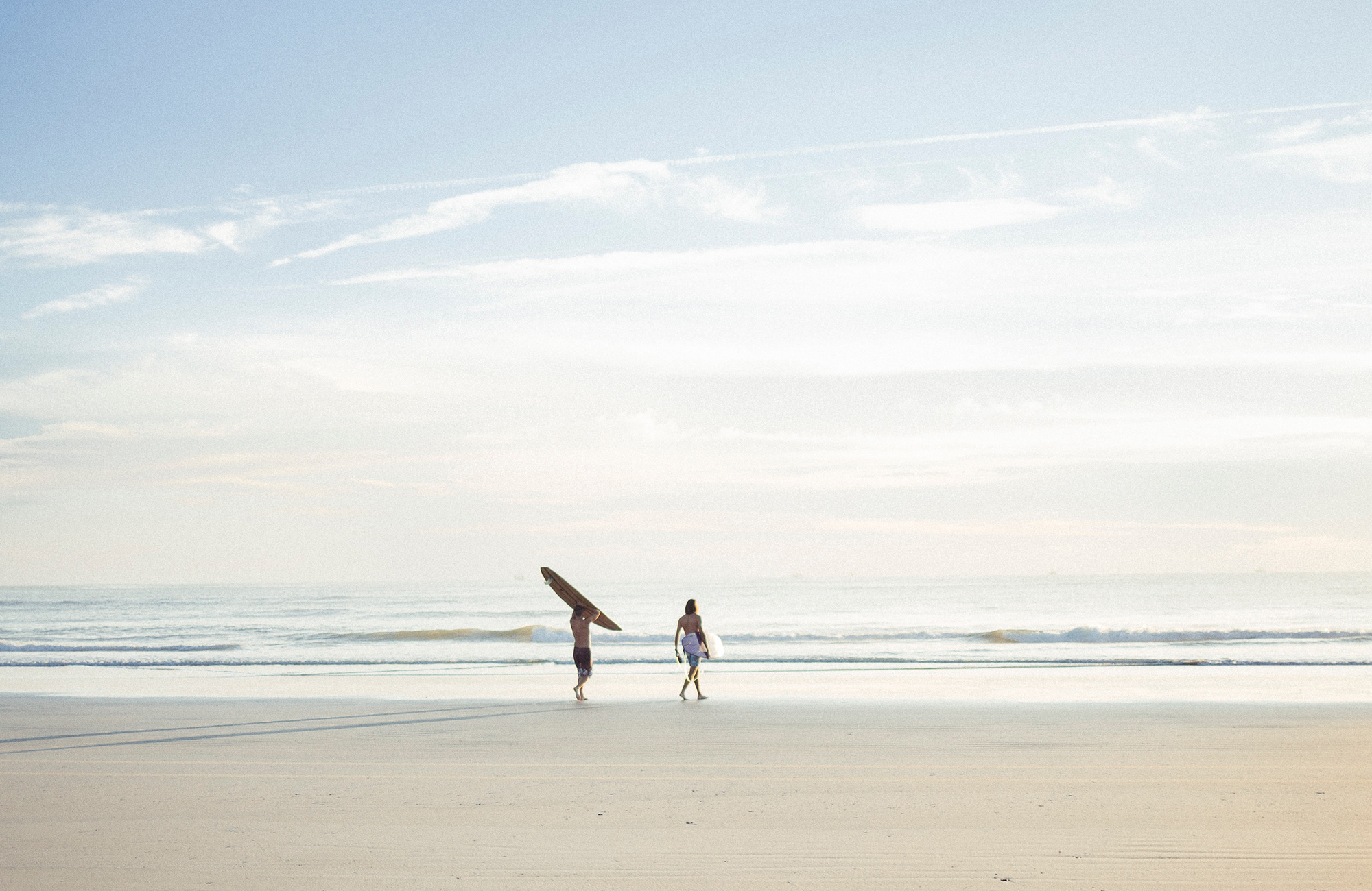 Image of two surfers walking towards the water in Portugal - KILROY