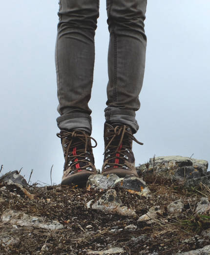 Close-up image of a woman's legs with hiking boots on her feet - KILROY