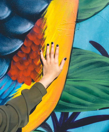 Image of a woman's hand on a colourful mural in Buenos Aires - KILROY