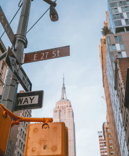 Image of road signs with a skyscraper in the background in New York City - KILROY
