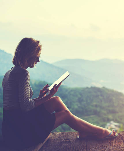 Image of a female traveller looking at a tablet - KILROY