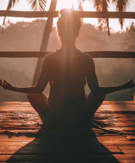 Image of a woman holding a yoga pose at sunset - KILROY