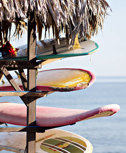 Image of surfboards stacked up on a beach in Portugal - KILROY