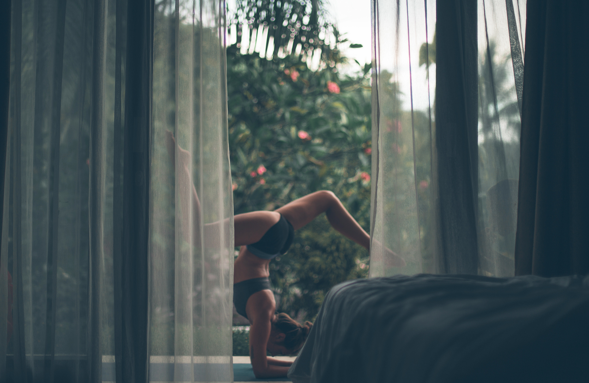 Image of a woman holding a yoga pose outside a hotel room - KILROY