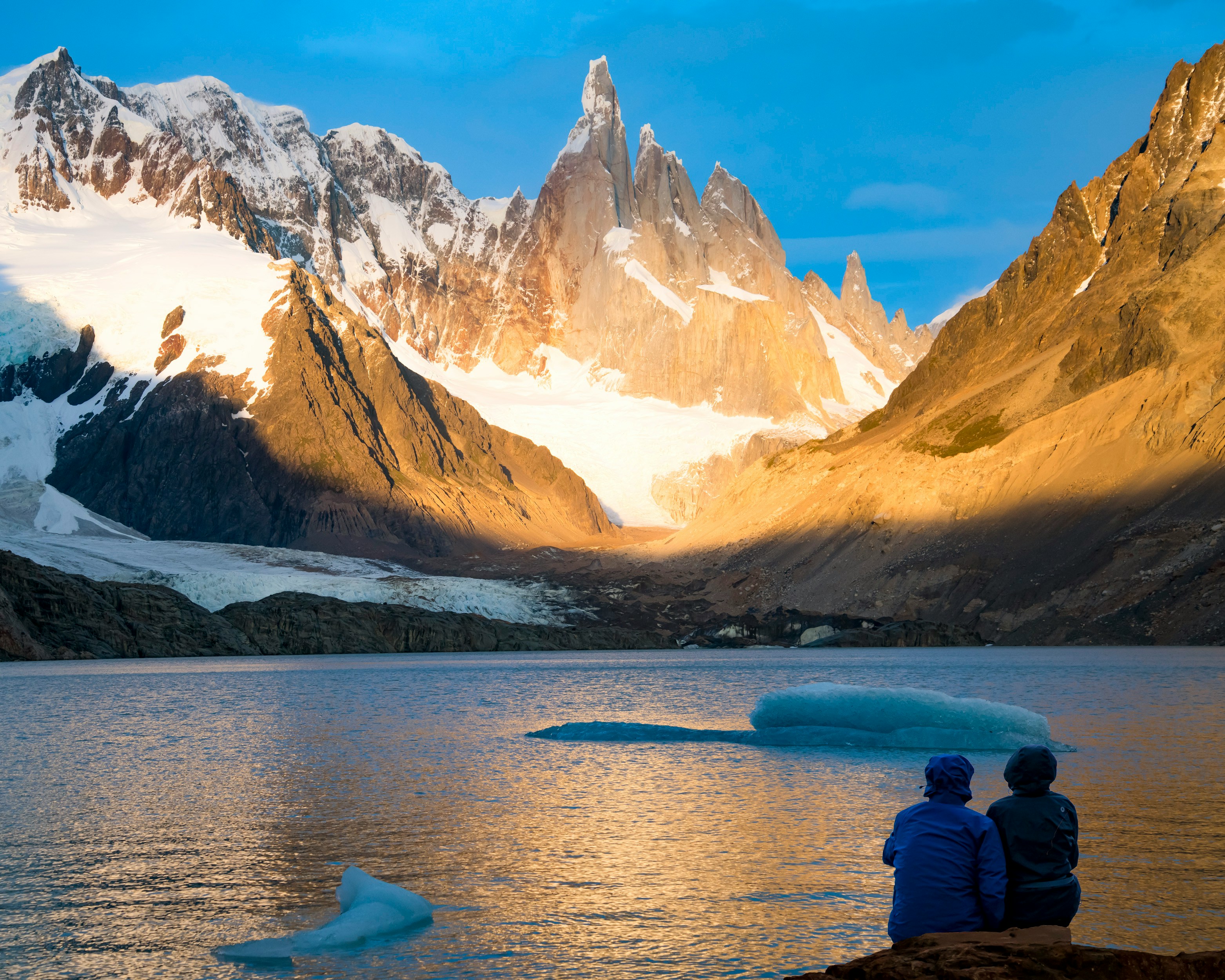 Image of two hikers looking at the famous Torres del Paine in Patagonia - KILROY