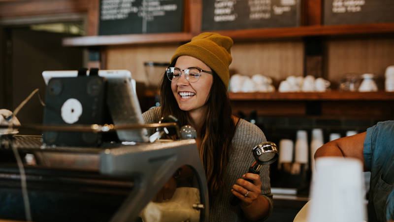 Image of a young woman working in a cafe on a working holiday - KILROY